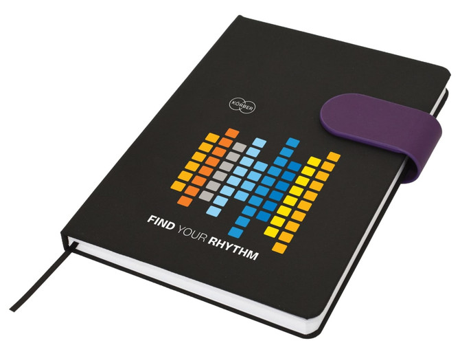 A black A5 notebook with a colourful graphic design and a purple elastic band closure. It features a logo.