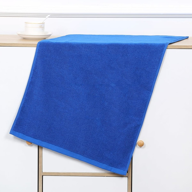 A blue gym towel is draped over a shelf, with a cup and saucer positioned beside it. The towel has a neat trim. A blue gym towel is draped over a shelf, with a cup and saucer positioned beside it. The towel has a neat trim.