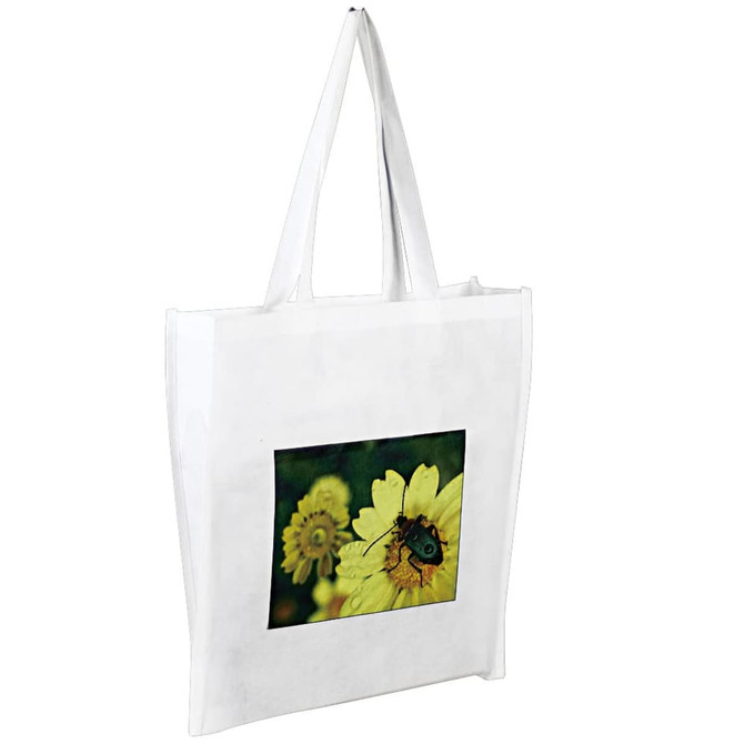 A white tote bag featuring a photograph of a beetle on a yellow flower. It has long handles for easy carrying.