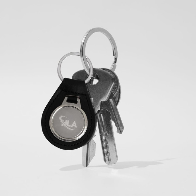 A metal keyring with a black PU leather holder, featuring multiple keys attached. The keyring has a logo.