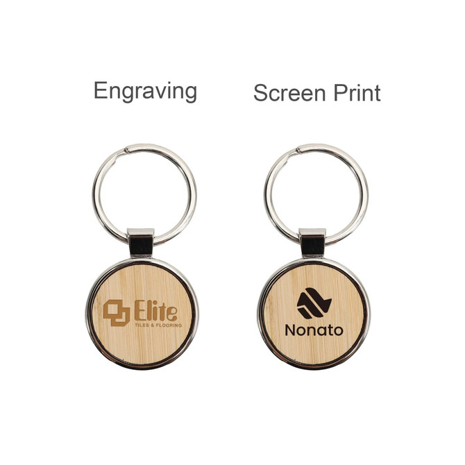 A round wooden keyring featuring a metallic rim, displaying engraved logos on a bamboo surface.