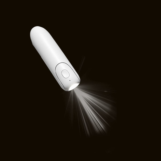 A white handheld mini fan with a built-in flashlight emitting light, featuring a simple button design.