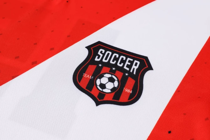 A red and white football jersey featuring a logo with a soccer ball and stripes.