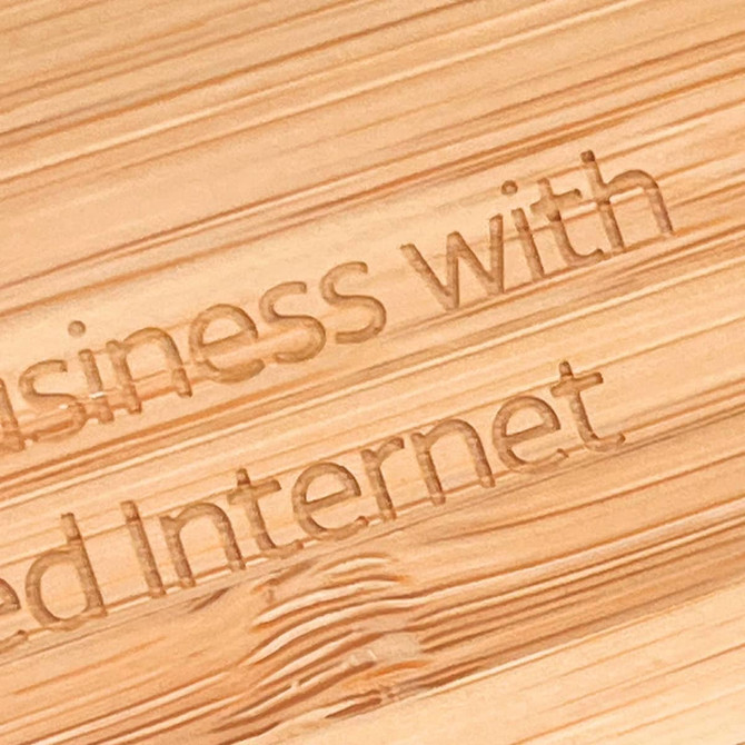 A close-up view of a bamboo surface engraved with text. The bamboo has a natural light brown colour.