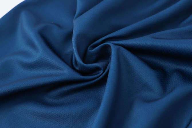A close-up of dark navy polyester fabric, showcasing its smooth and soft texture.