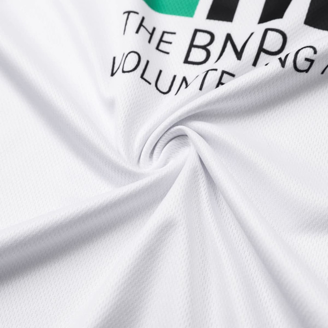 A close-up of a white round-collar tee shirt featuring a logo, showcasing the fabric texture.