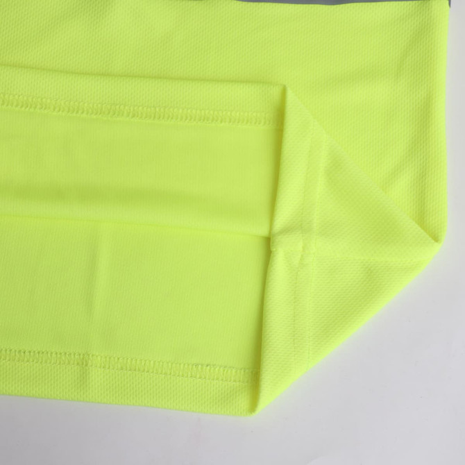 A vibrant yellow polyester polo shirt featuring a reflective element and a branded label.