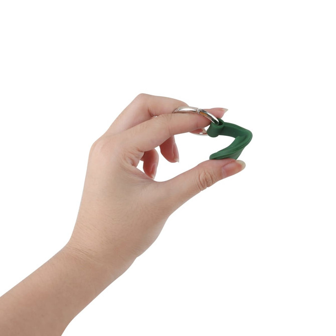 A green Air Tag protective case with a keyring, held by a hand against a white background.