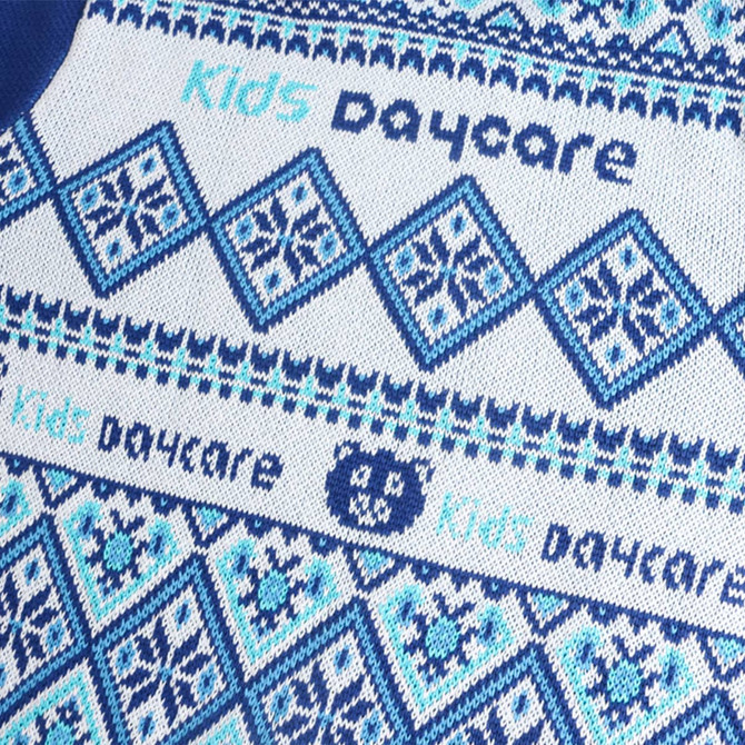 A blue and white jacquard sweater featuring geometric patterns and a logo, designed for kids.