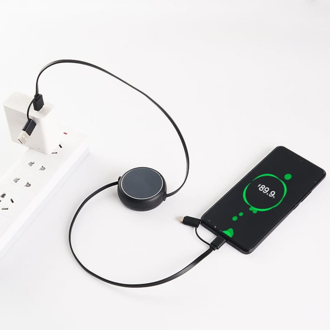 A retractable portable charging cable in black, connected to a power source and a smartphone, displaying a charging indicator.