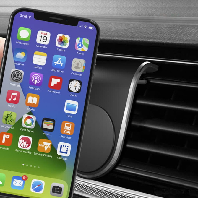 A smartphone in front of a black magnetic car phone holder, designed for air vent installation.
