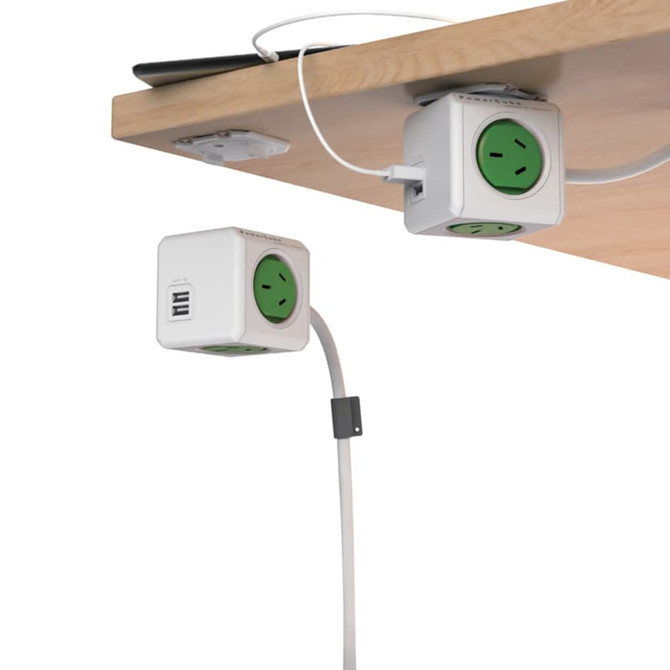 A white Power Cube with green sockets and USB ports, mounted under a wooden surface for easy access.