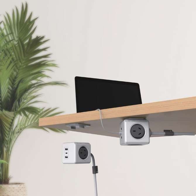 A white Power Cube Extended Trio USB with multiple ports, attached under a desk with a laptop above.