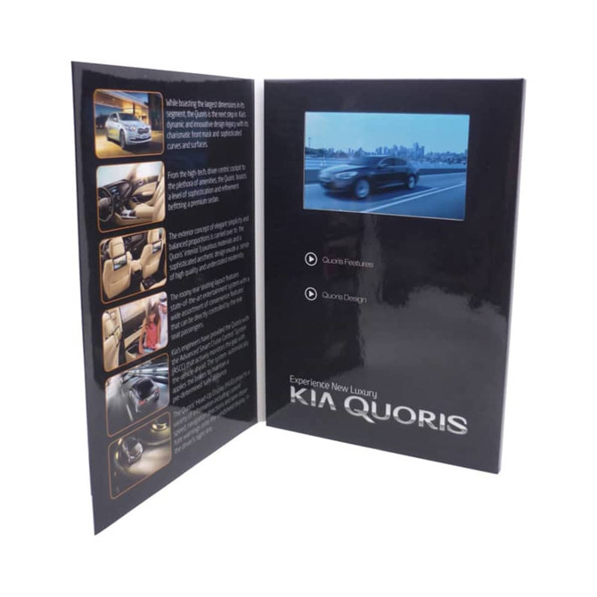 A black promotional booklet featuring images and an LCD screen displaying a video, showcasing the Kia Quoris.