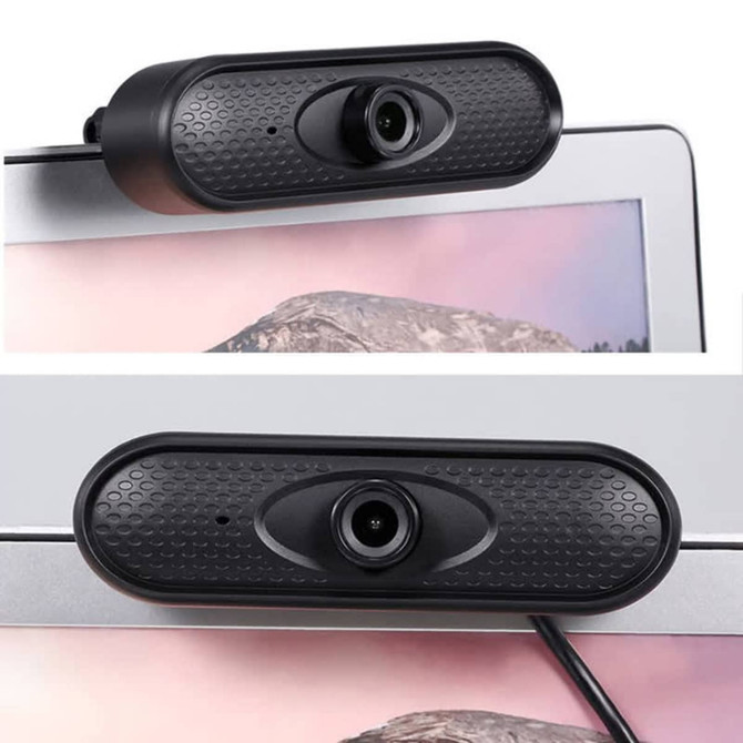 A black webcam camera mounted on the top of a computer monitor, featuring a textured surface and lens.