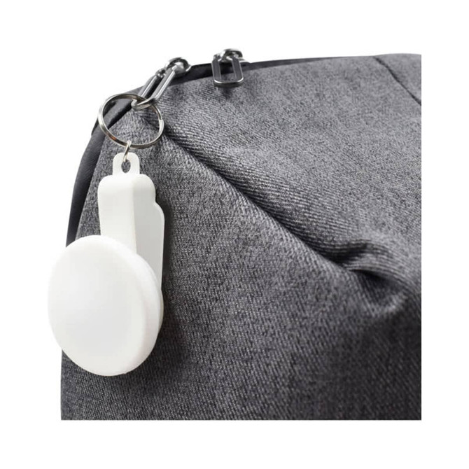 A grey bag with a white keyring attachment prominently displayed on the zipper.