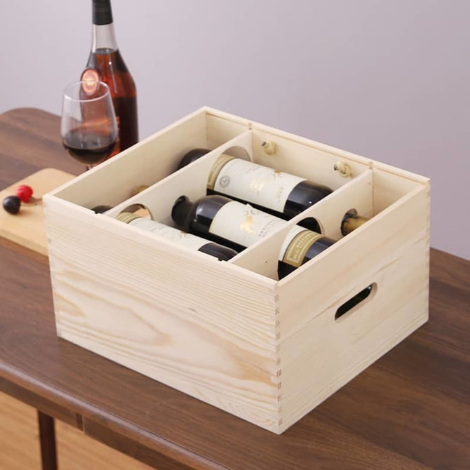 A wooden box in a natural finish, holding six wine bottles, with a glass of red wine on the table beside it.