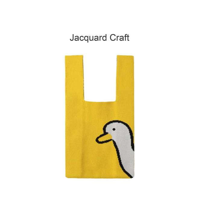 A yellow knitted handbag featuring a duck design and a square handle. The bag has a logo on it.