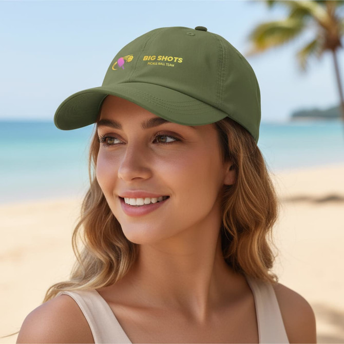 A lightweight green cap with an embroidered logo, set against a beach backdrop and palm trees.