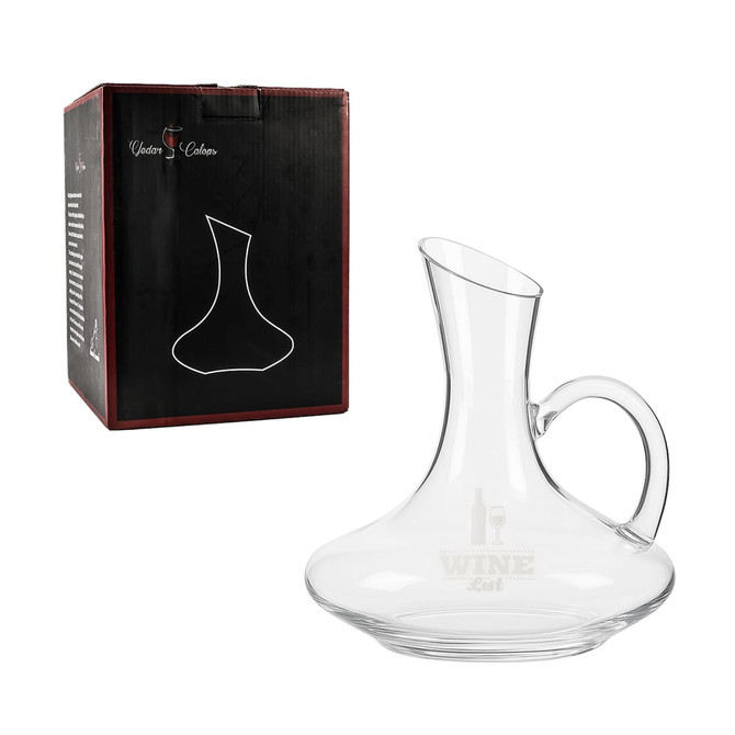 A glass wine decanter with a handle, placed beside its black box featuring a logo. Transparent and elegantly shaped.