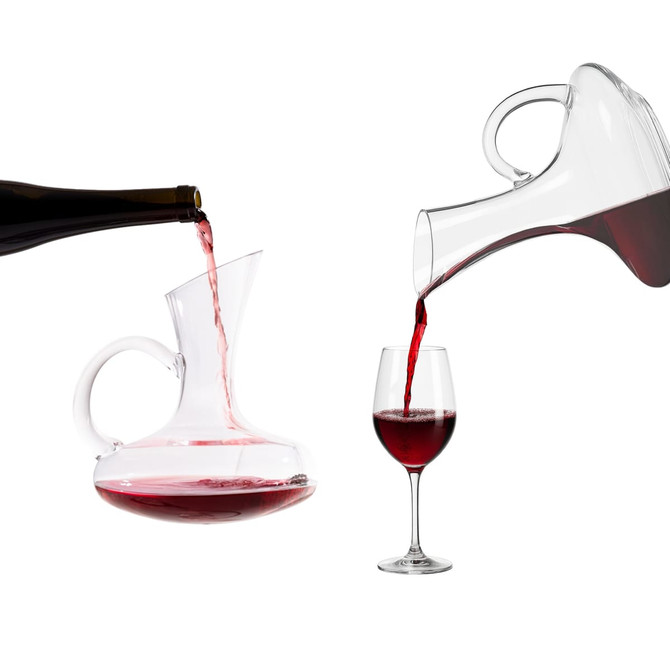 A glass handled wine decanter is pouring red wine into a glass, with a wine bottle positioned nearby.