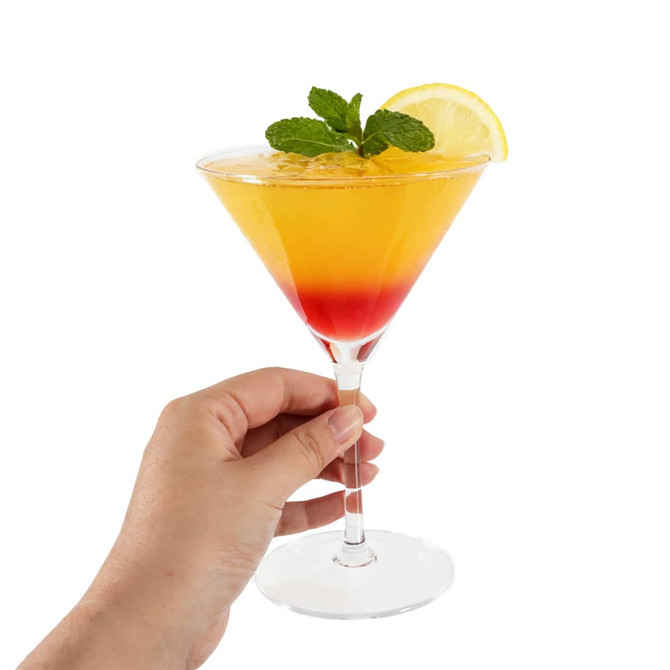 A classic martini glass filled with a gradient drink in orange and red, garnished with a lemon slice and mint.