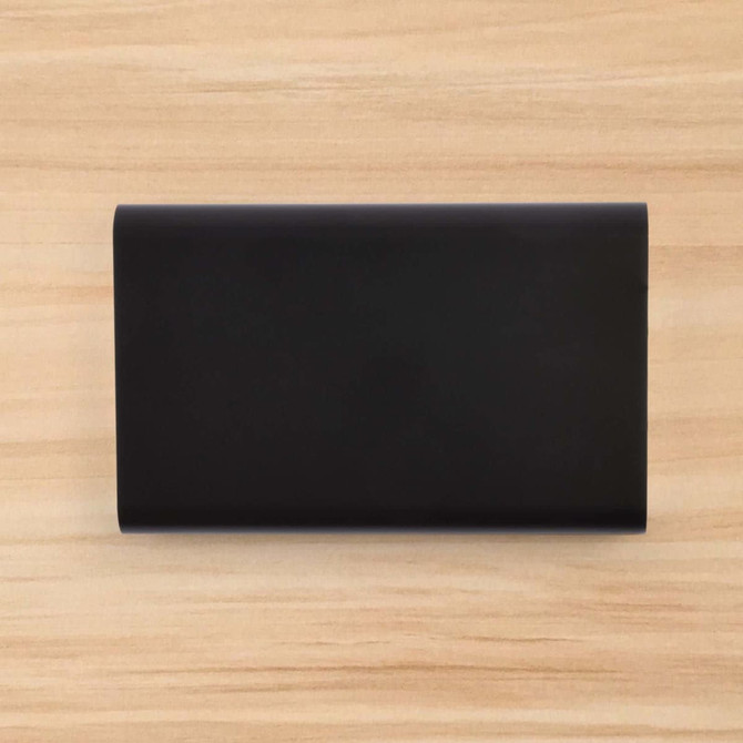 A sleek black Octavius 8,000mAh Power Bank is displayed on a wooden surface.