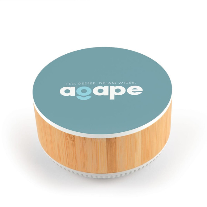 A round speaker with a bamboo base and a blue top featuring a logo and text in white.
