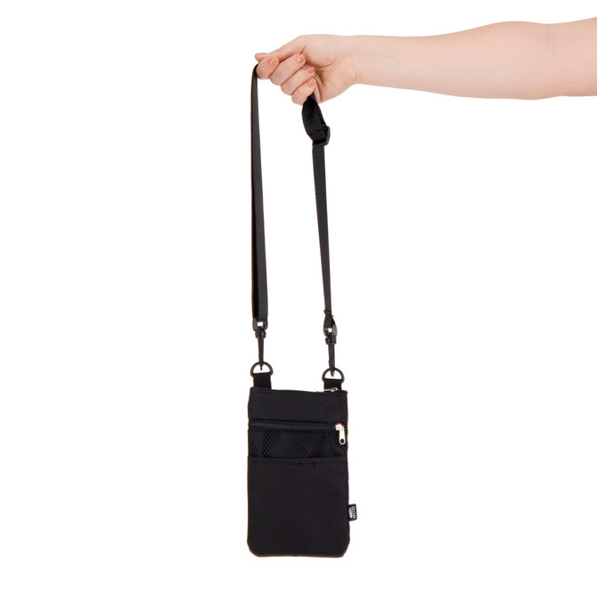 A black Wallaby Neck Pouch with a strap is being held by a hand, featuring a front zip pocket and branding.