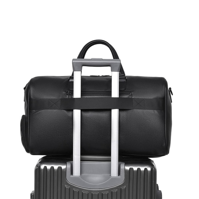 A black polyurethane duffle bag resting atop a silver suitcase, featuring a handle for easy transport.
