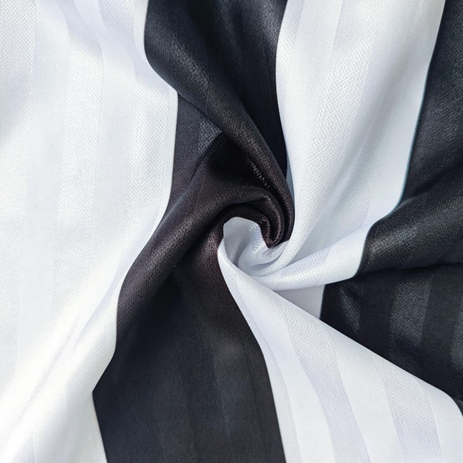 A close-up of a fabric featuring alternating black and white stripes, showcasing a smooth texture.