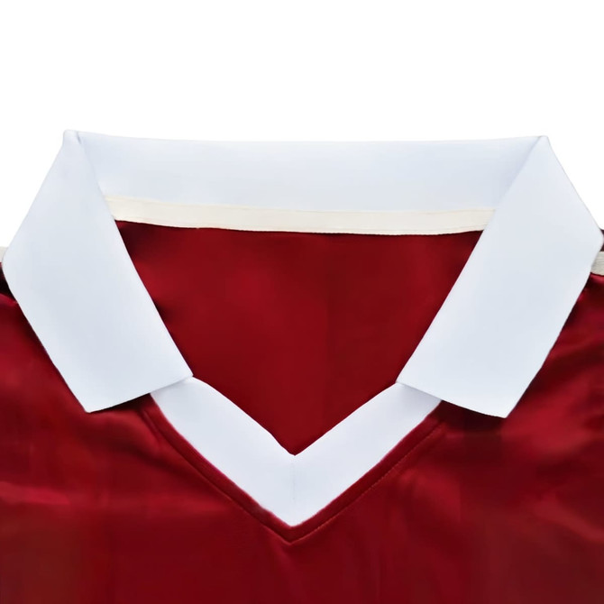 A red sports jersey with a white collar and a V-neck design, featuring a logo. 
