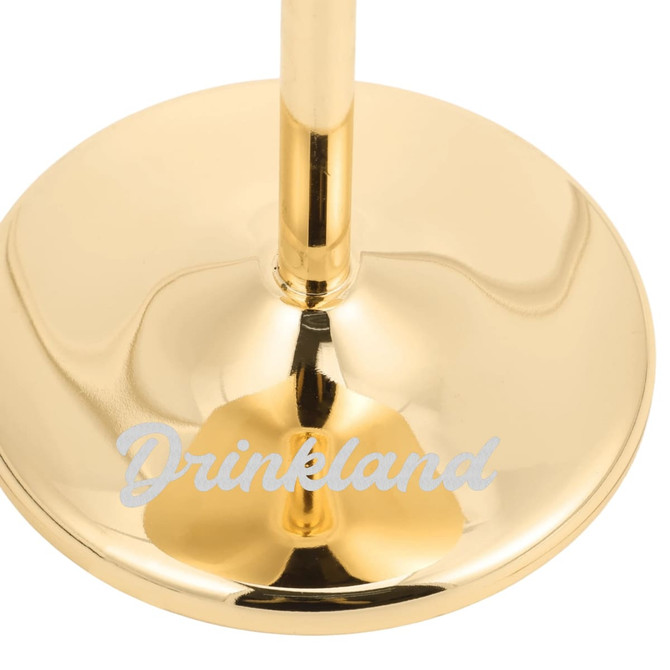 A stainless steel martini goblet with a shiny gold finish and a base that has a logo.