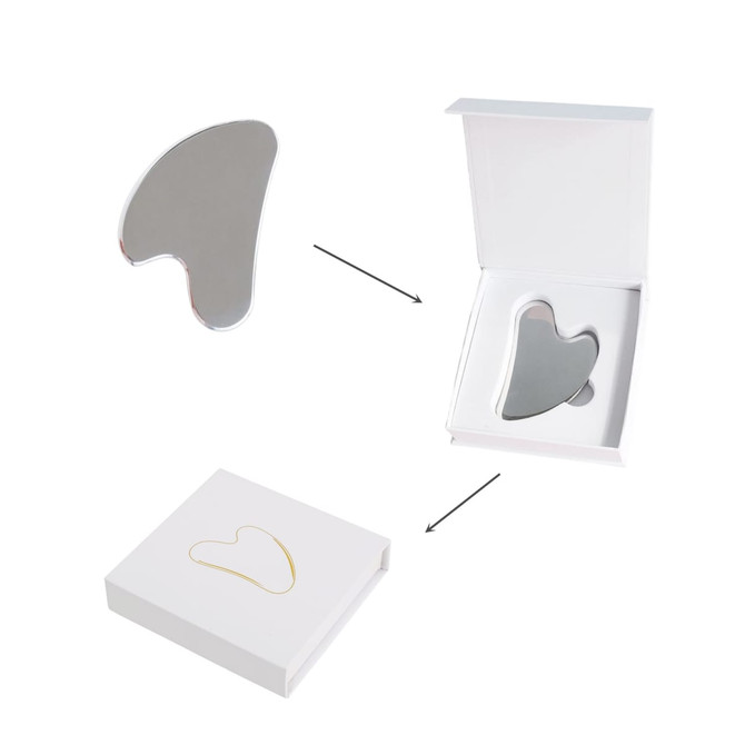A stainless steel gua sha massage tool in a white box, featuring a sleek and reflective surface.