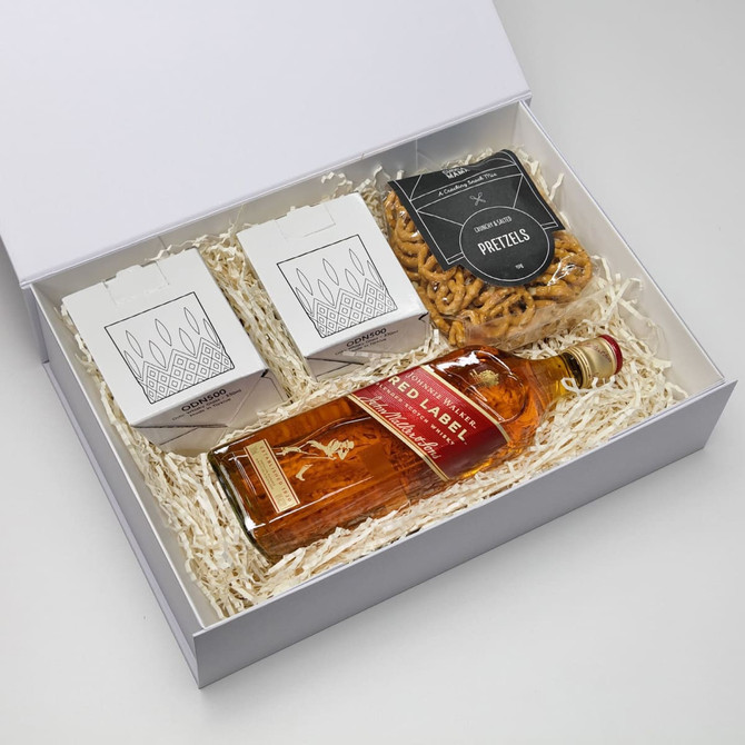 A gift box containing a bottle of whisky, pretzels, and two takeout-style containers. Predominantly brown and white.