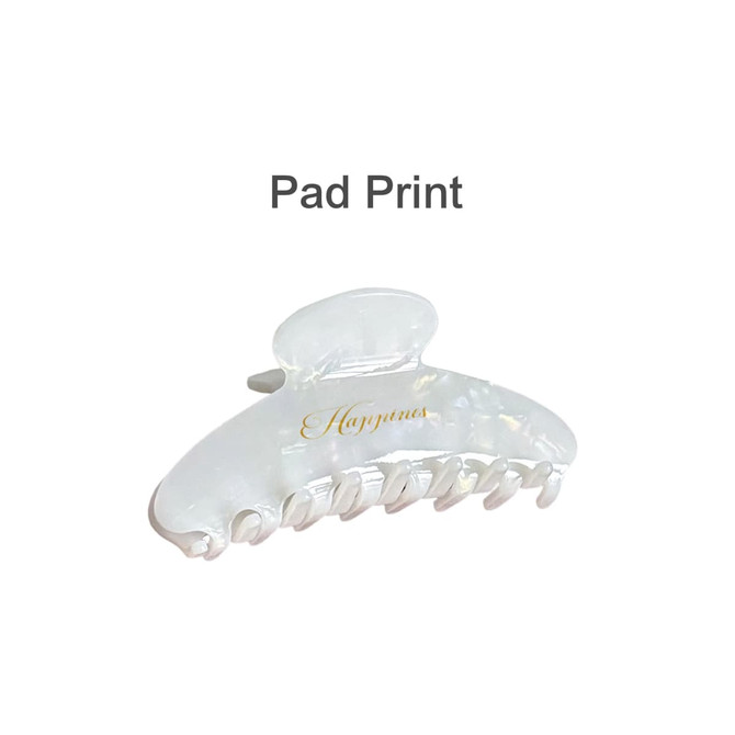 A transparent acetate hair clip in white with a glossy finish and an elegant design. Features a logo on the side.