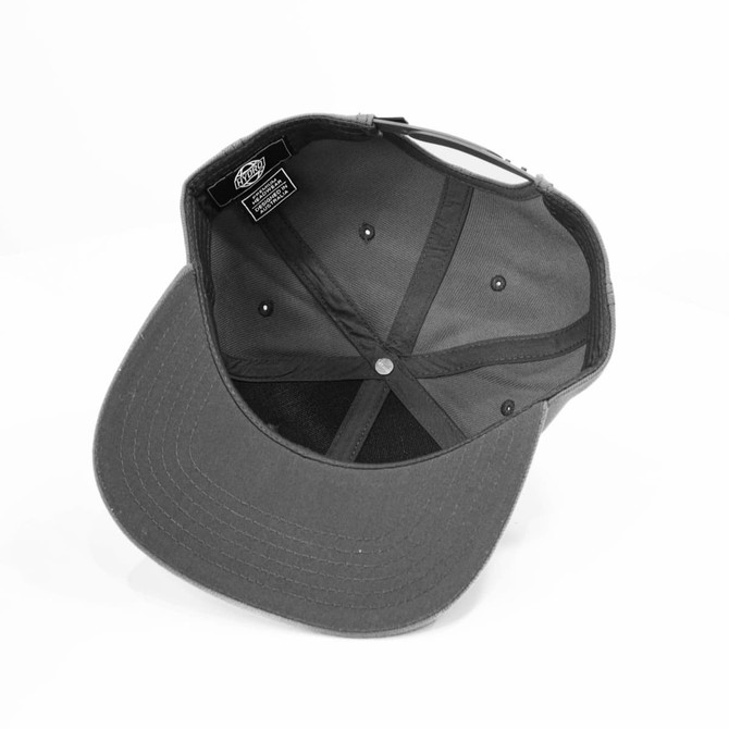 A black cap with a flat brim and an interior view showcasing its structured crown and six ventilation eyelets.