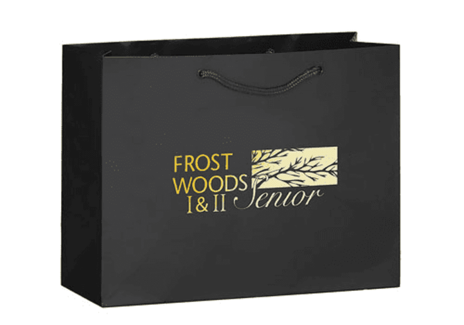 A black tote bag featuring a logo design in gold and a twisted handle.