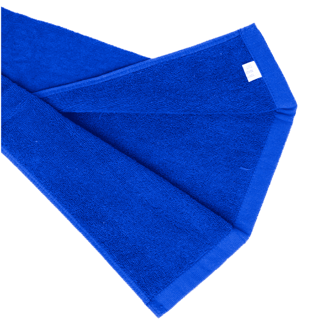 A blue cotton golf towel folded neatly, featuring a small label in one corner and a textured surface.