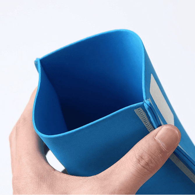 A blue EVA foam supporter hand with a flexible design, held in a person's hand. It features a logo.