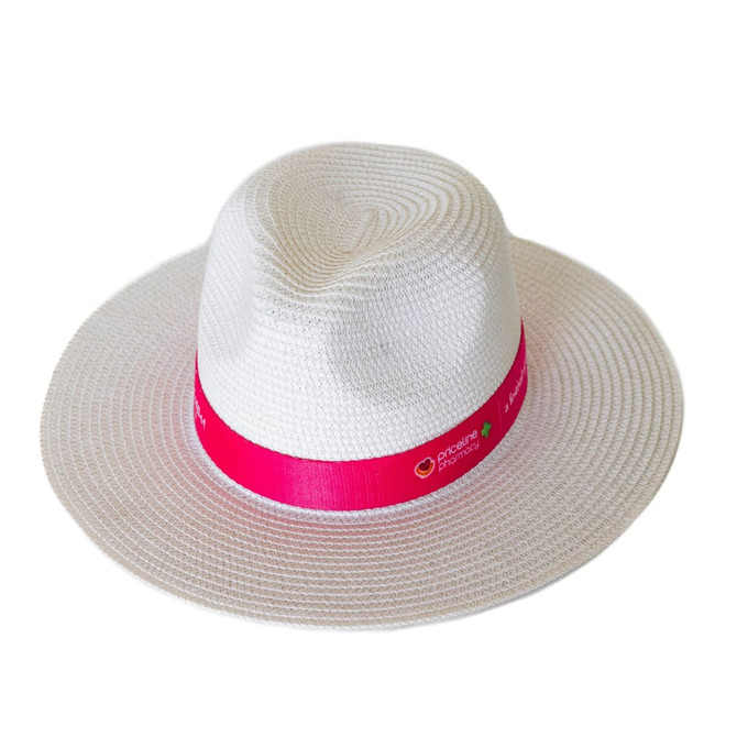 A white Fedora paper straw hat with a pink ribbon band, featuring a logo.