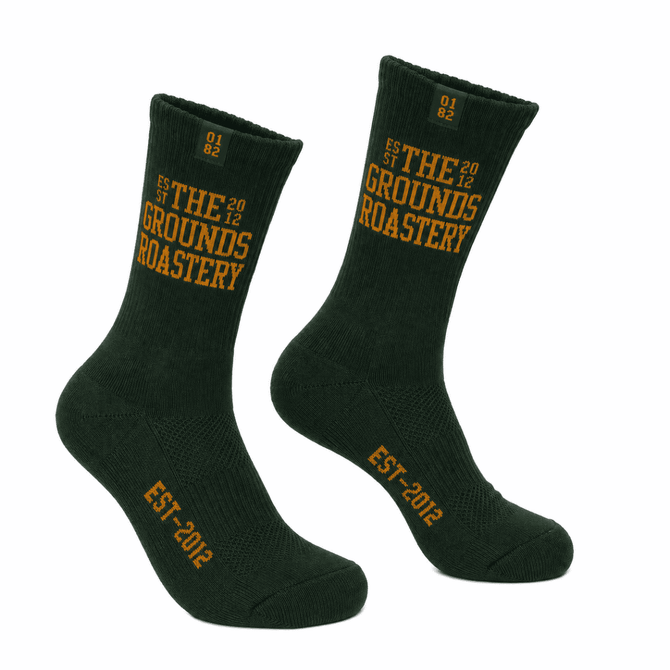 A pair of dark green crew socks featuring yellow text and a logo. Suitable for casual wear.