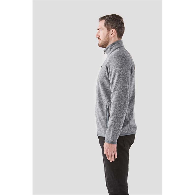 A grey full zip fleece jacket featuring a high collar and side pockets, shown on a model from the side.