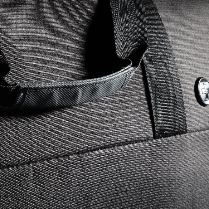 A black duffle bag featuring a textured fabric and a sturdy handle, with a logo visible on the side.