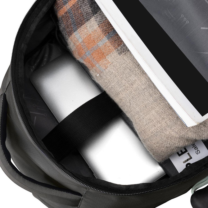 A green backpack interior features a laptop, a blanket, and documents, all nestled inside.