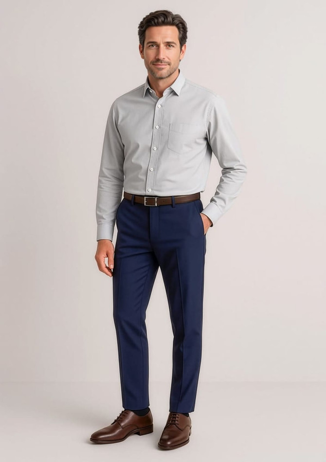 A man wearing a grey shirt and navy slim fit flat front pants, complemented by brown shoes and a belt.