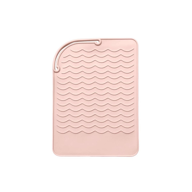 A pink silicone hair straightener pad with a textured wave design for heat protection and stability.