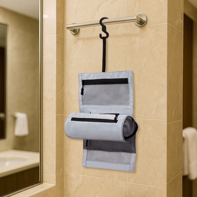 A grey multifunctional toiletry travel bag hangs on a towel rack, featuring multiple zippered compartments and mesh panels.