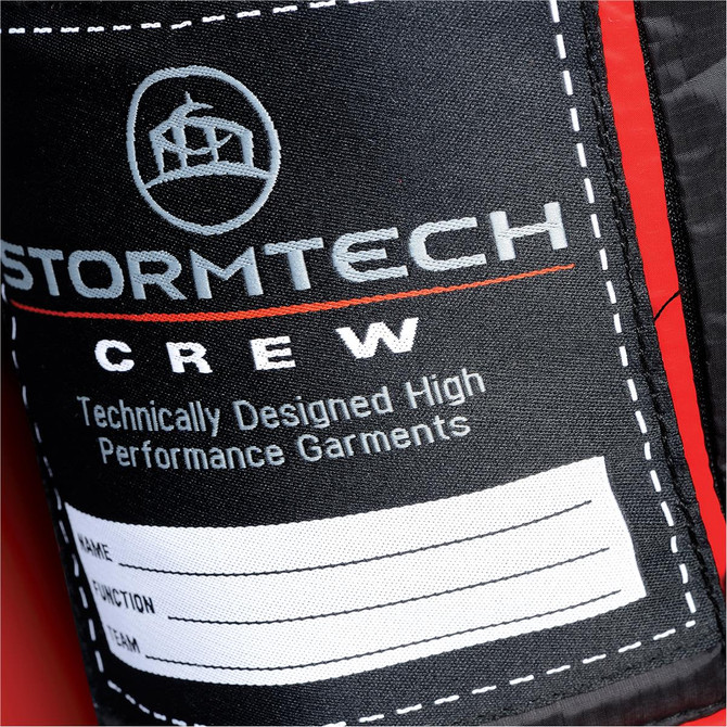 A close-up of a label on a red puffer jacket, featuring a logo and space for personal details.