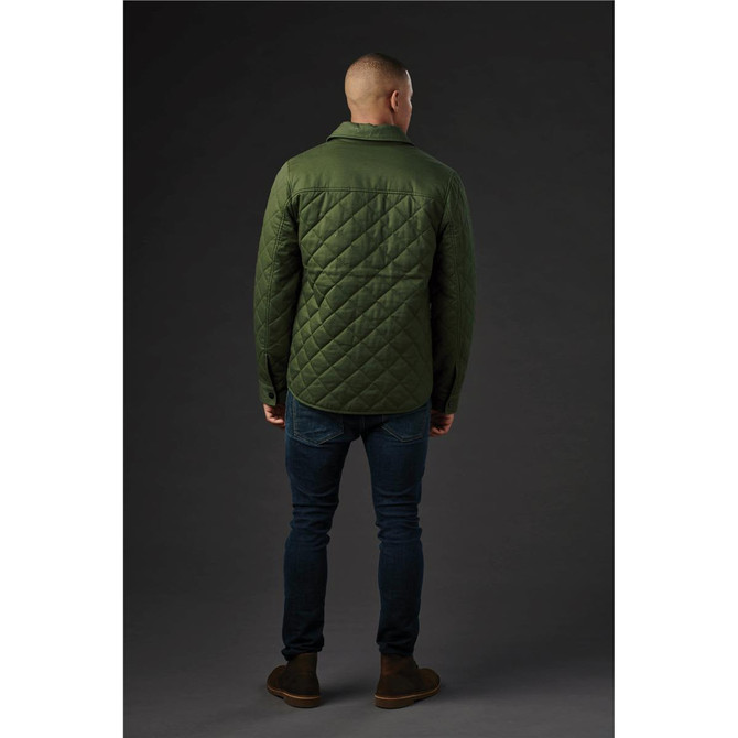 A green quilted jacket viewed from the back, featuring a collar and a logo. Worn with dark jeans and boots.
